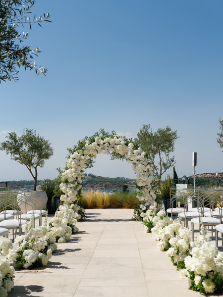 Circular white floral ceremony arch at Four Seasons Astir Palace Athens during luxury Athens wedding