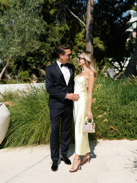 Well-dressed couple in formal attire arriving at Four Seasons Astir Palace Athens wedding