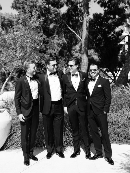 Group of groomsmen posing in formal black-tie attire before ceremony on the Athenian Riviera