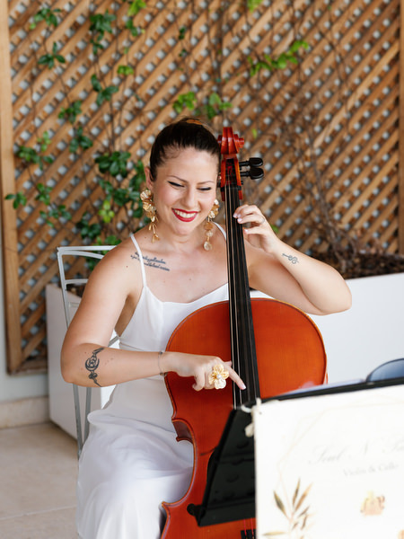 Musician performing cello during luxury lakeside wedding ceremony on the Athenian Riviera