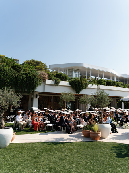 Outdoor ceremony setup with guests seated on manicured lawn at Four Seasons Athens