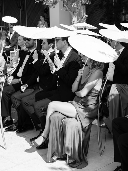 Elegant black-tie guests seated in modern chairs during outdoor ceremony on the Athenian Riviera