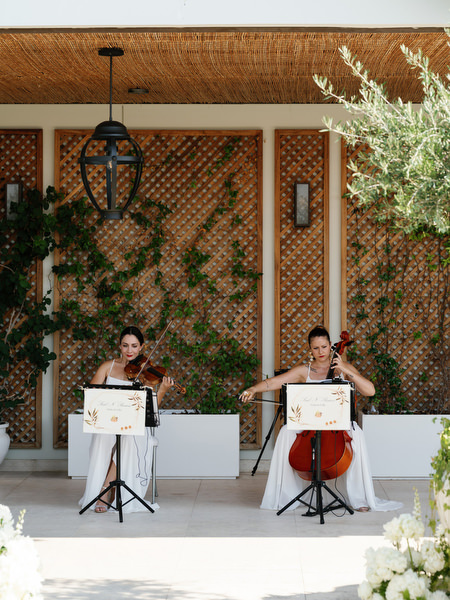 Violinist and cellist performing during outdoor ceremony at Four Seasons Astir Palace Athens