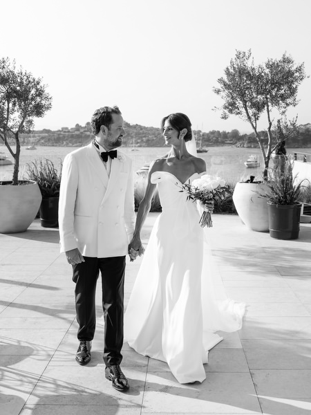 Bride and groom walking hand-in-hand during elegant black-tie wedding in Greece