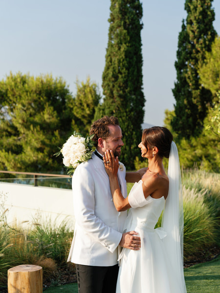 Bride gently touching groom’s face during romantic portrait session in Athens