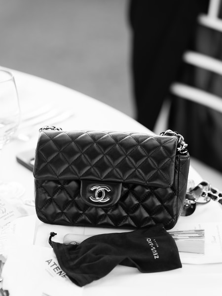 Black quilted Chanel handbag placed on reception table during elegant Athenian Riviera wedding