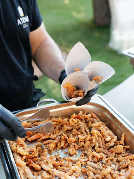 Chef serving fried seafood cones during outdoor cocktail hour at Vouliagmeni Lake wedding