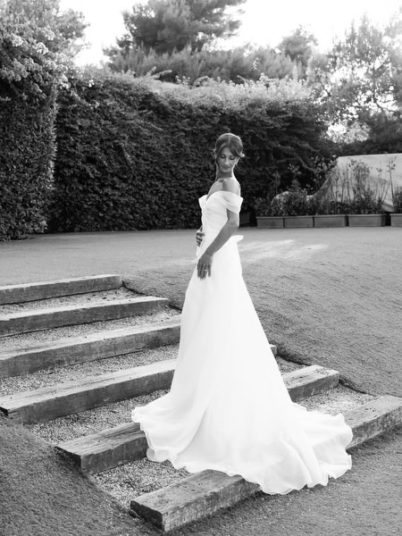 Bride posing gracefully on stone steps during black-tie Athenian Riviera wedding