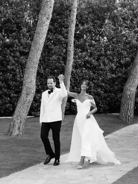 Bride and groom entering reception hand-in-hand with celebratory energy