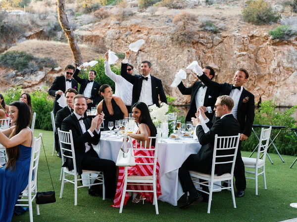 Wedding guests laughing and celebrating during high-energy dinner moment