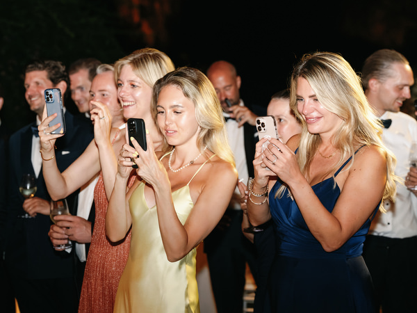 Stylish guests recording dance floor celebration during Athens black-tie wedding