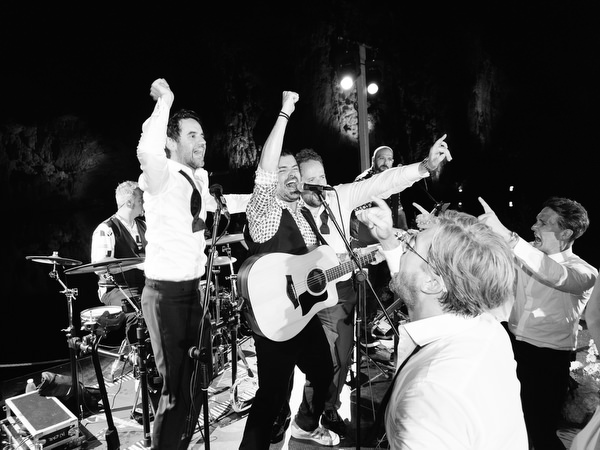 Live band encouraging guests to sing and raise hands during reception party