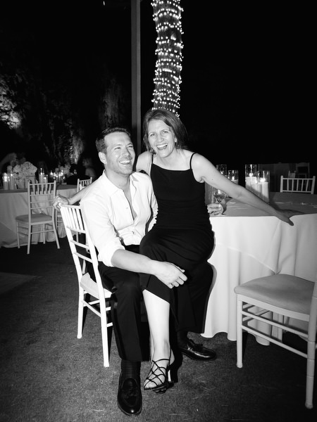 Guest couple seated and smiling beside candlelit reception table