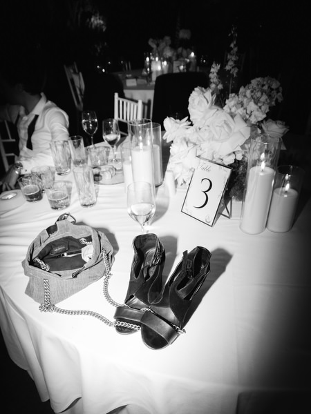 Elegant reception table with floral centerpiece, table number, and evening accessories