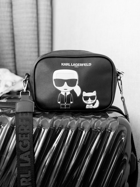 Black and white detail of Karl Lagerfeld bridal bag on suitcase during bride’s wedding morning in Athens