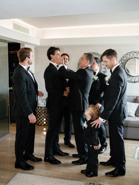 Emotional groom and father moment with groomsmen during Athens Riviera destination wedding preparations