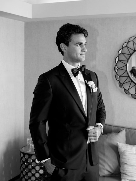 Editorial portrait of groom in black tuxedo during luxury Island Resort Athens wedding at Divani Apollon Palace and Thalasso