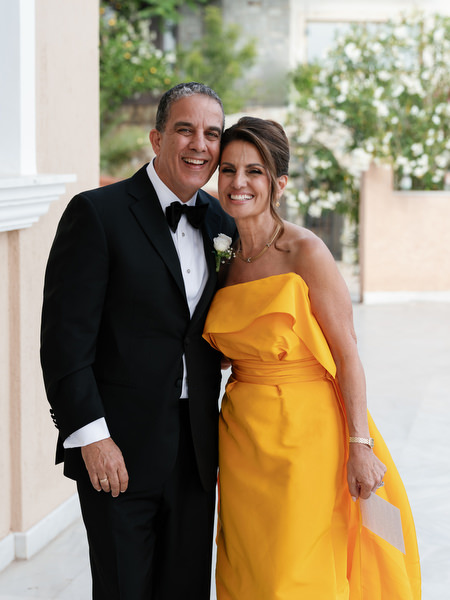 Parents of the bride smiling outside church before Greek Orthodox wedding in Athens