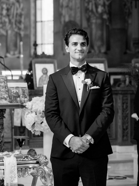 Groom standing at the altar inside Greek Orthodox church in Athens before bride’s entrance