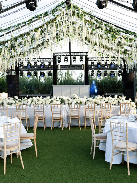 Elegant reception setup beneath hanging greenery and lighting structure at Island Resort Athens Riviera overlooking the sea
