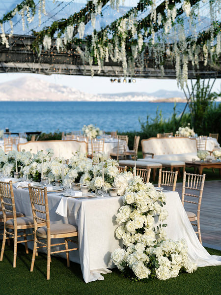 Cascading white florals decorating head table at Island Resort Athens Riviera wedding reception