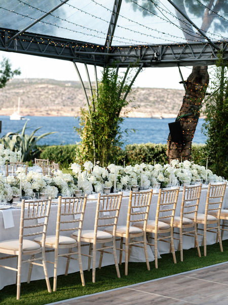 Luxury white floral banquet table setup at Island Resort Athens Riviera reception with ocean views