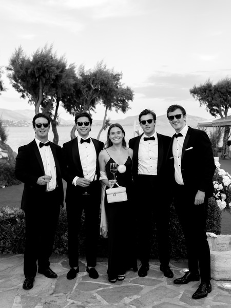 Elegant wedding guests in black tie attire posing during cocktail hour at Island Resort Athens Riviera