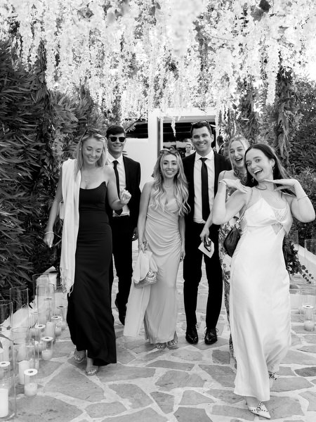 Wedding guests walking beneath cascading white floral tunnel at Island Resort Athens Riviera reception