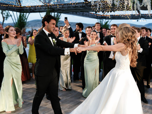 Bride and groom twirling on dance floor during seaside reception at Island Resort Athens Riviera