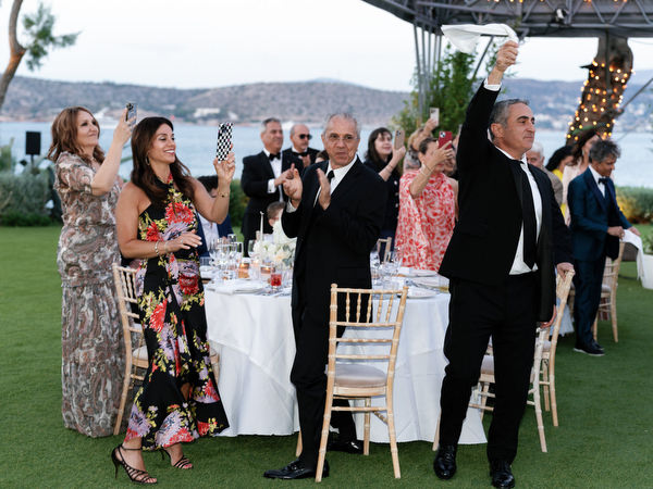 Guests standing and applauding during emotional moment at Athens Riviera wedding
