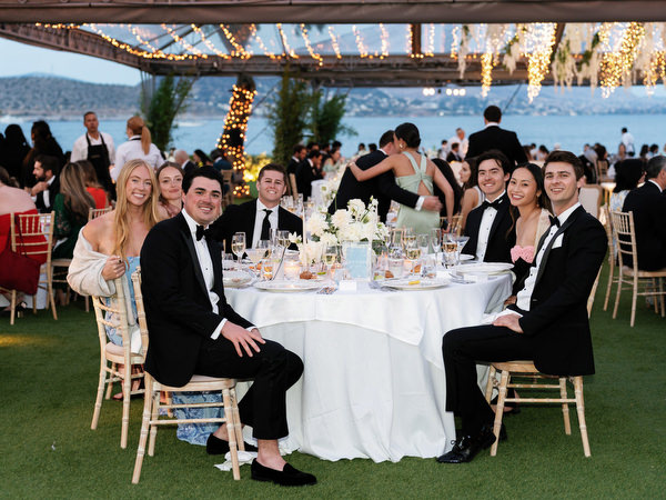 Guests seated at candlelit round table during luxury Island Resort Athens Riviera wedding