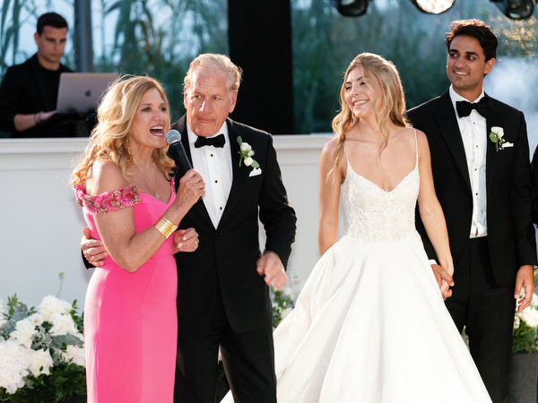 Bride smiling beside her parents during heartfelt speech at Athens Riviera wedding reception