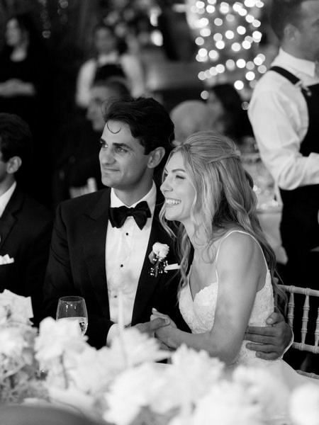 Bride and groom seated together listening to reception speech at luxury Athens Riviera wedding