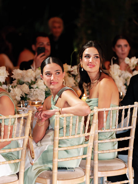 Bridesmaids in sage green gowns seated at candlelit table during Island Resort Athens Riviera wedding