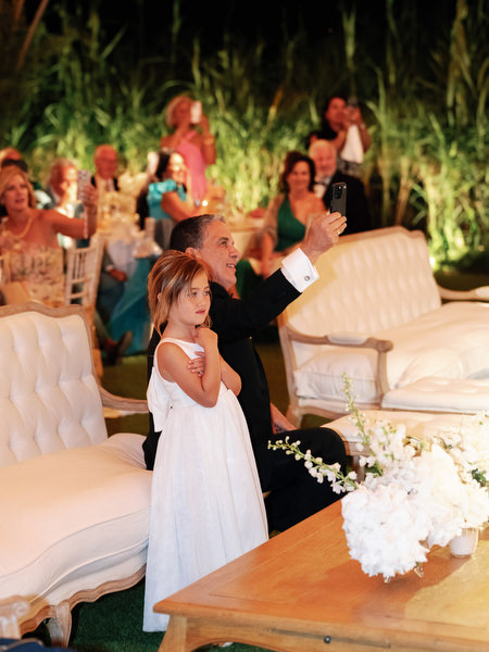 Flower girl standing near lounge seating during evening celebration at Island Resort Athens Riviera