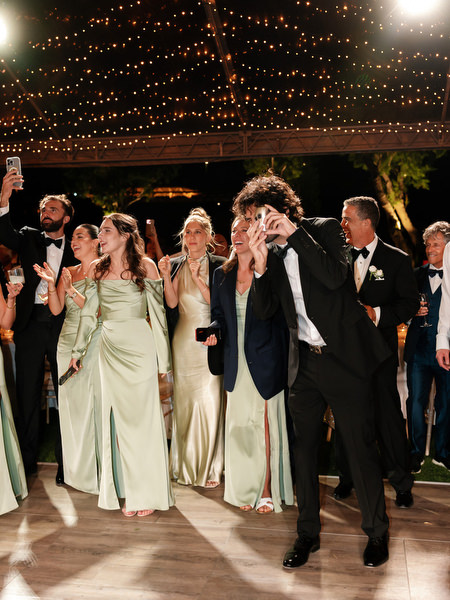Wedding guests celebrating during champagne tower moment at Athens Riviera reception