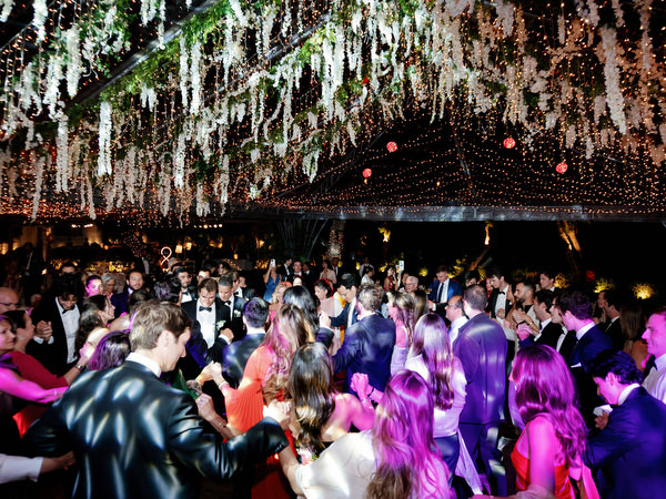 Guests dancing under hanging greenery and vibrant lighting at Island Resort Athens Riviera