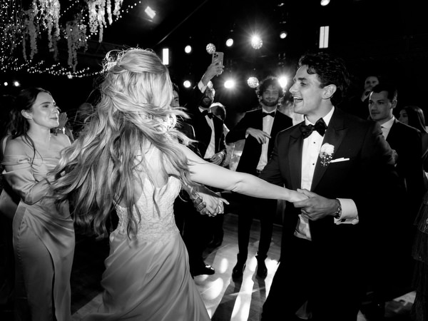 Bride spinning on crowded dance floor during high-energy Athens Riviera wedding party