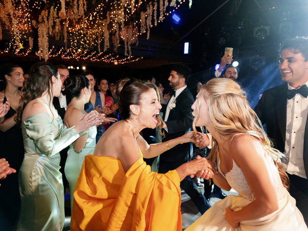 Wedding guests clapping and cheering during lively reception moment at Island Resort Athens Riviera