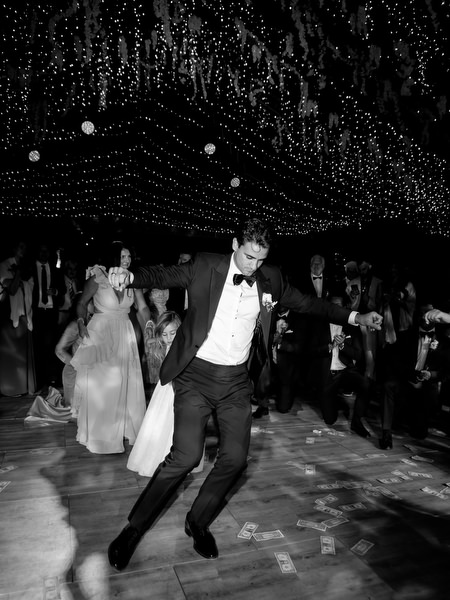 Groom dancing energetically on packed dance floor during Island Resort Athens Riviera wedding