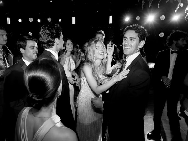 Bride and groom laughing while dancing among guests at Island Resort Athens Riviera