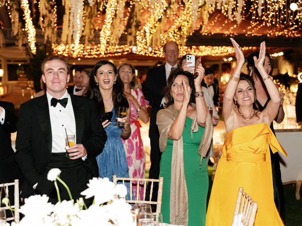 Friends cheering and singing during high-energy reception celebration in Athens