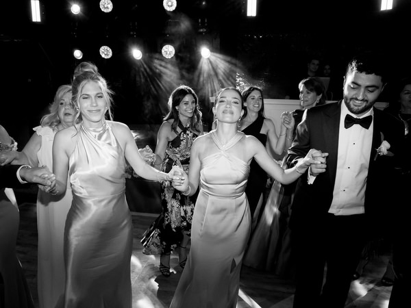 Wedding guests dancing enthusiastically during late-night Island Resort Athens Riviera celebration