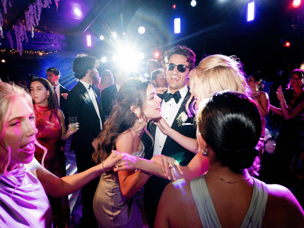 Guests dancing beneath vibrant stage lights at Island Resort Athens Riviera reception