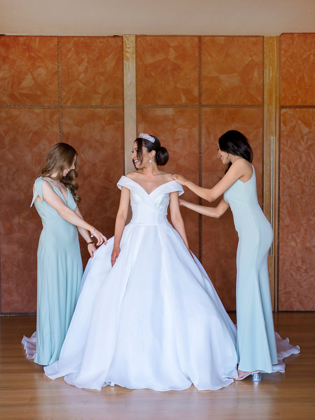 Bridesmaids helping bride with gown during Athens Riviera wedding