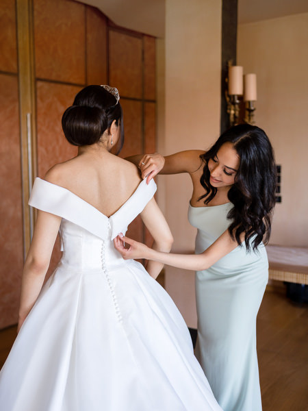 Bride and bridesmaid adjusting gown during Golf Privé Glyfada wedding