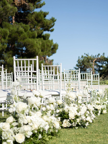 Wedding ceremony setup at Golf Privé Glyfada with white floral aisle