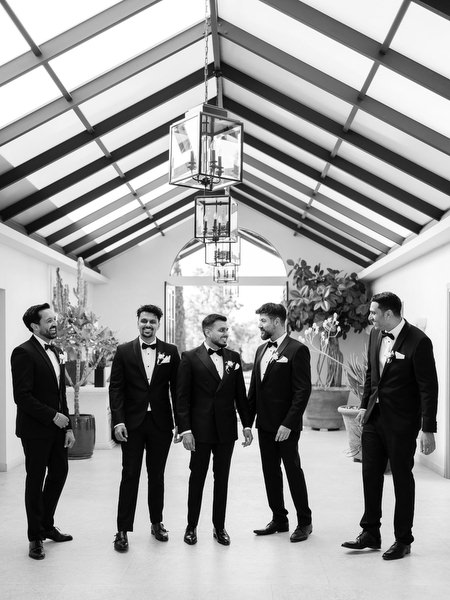 Black and white portrait of groom and groomsmen walking to ceremony