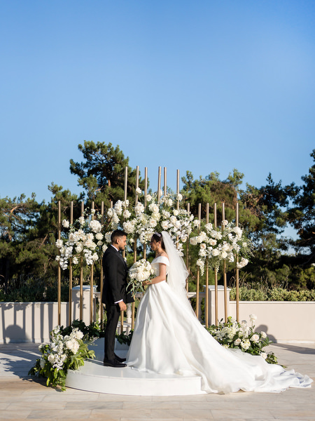 Bride and groom standing beneath floral arch during Athens wedding