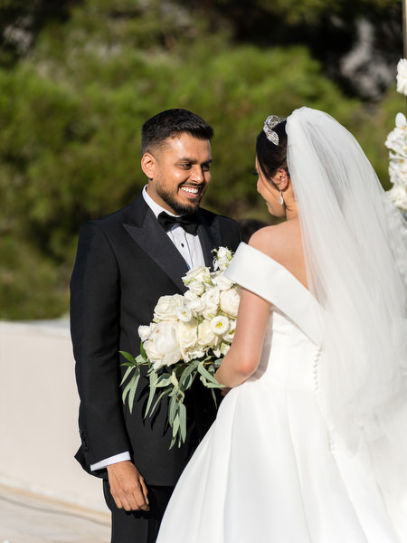 Bride and groom portrait under floral arch at Golf Privé Glyfada